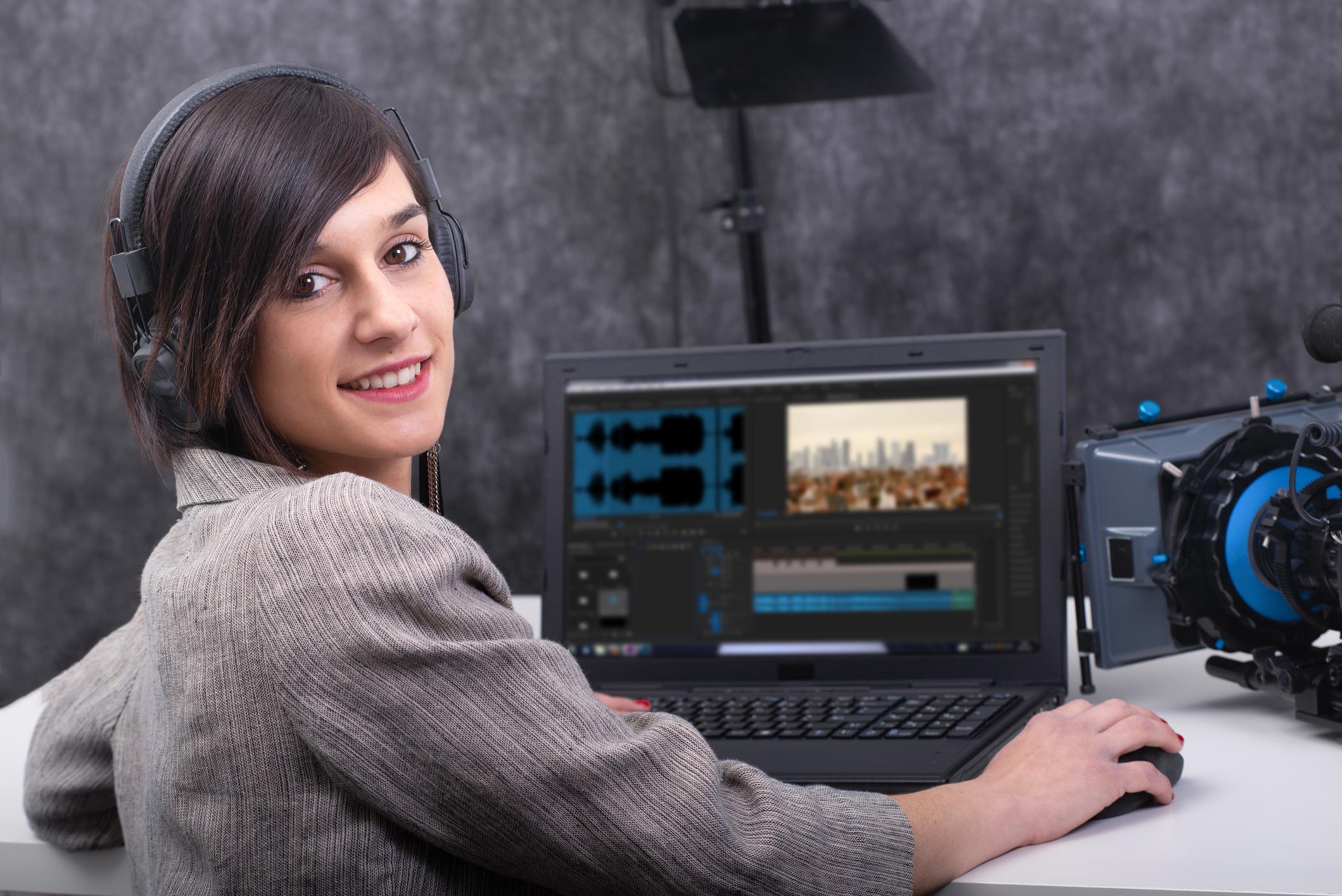 a smiling young woman video editor working in studio